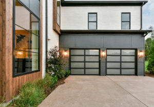 Black aluminum and glass garage doors on a modern home.