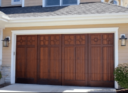 Exterior view of wooden garage door on a home with pale yellow siding.